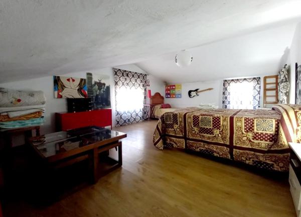 Dormitorio abuhardillado con varias camas