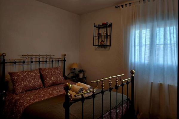 Dormitorio con cama de forja y ventana