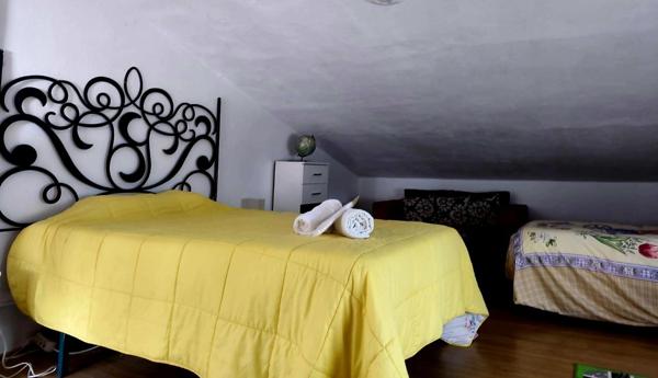 Dormitorio abuhardillado con cama doble y cama individual