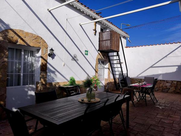 Patio exterior con mesas y escalera a la terraza